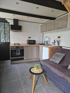 cocina y sala de estar con sofá y mesa en Maisonnette à 200m de la plage avec parking gratuit en Berck-sur-Mer