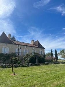 a large house with a grass yard in front of it at Château Gautoul in Puy-lʼÉvêque