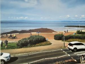 a view of a beach with a white car parked on a street at Morecambe Central balcony with sea view in Morecambe