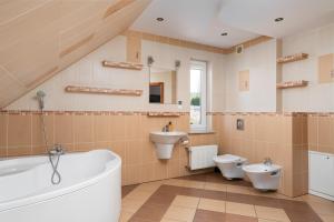 ein Badezimmer mit 2 WCs, einer Badewanne und einem Waschbecken in der Unterkunft Dom Na Skarpie in Wałbrzych