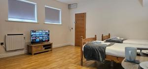 a room with two beds and a flat screen tv at Modern Studio apartment in Town center in Ipswich
