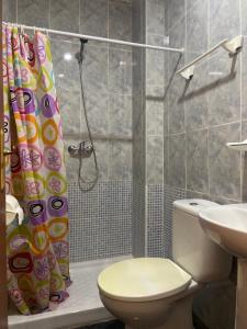 a bathroom with a toilet and a shower curtain at La Ferroviaria - Habitaciones Con Baño Privado Sin Ascensor in Zaragoza
