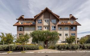 un gran edificio de apartamentos con una casa en LOCAR-IN GRAMADO- Maria Antonia, en Gramado