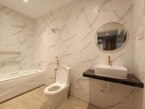 een badkamer met een toilet, een wastafel en een spiegel bij Kesuma Homestay Pantai Murni in Yan