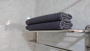 a stack of towels on a glass shelf in a bathroom at Carmen Apartamento Millón - Private roof terrace with Jacuzzi & BBQ in Nerja +23 photos