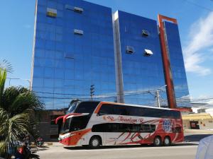 um autocarro vermelho e branco estacionado em frente a um edifício em RIO DULCE HOTELES - TARAPOTO em Tarapoto