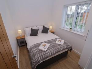 a bedroom with a bed with two towels on it at Elm Lodge in Ashbourne