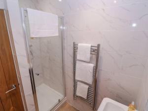 a white bathroom with a shower and a sink at Elm Lodge in Ashbourne