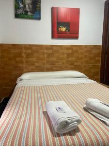uma cama com duas toalhas em cima em La Ferroviaria -Pensión No Fumadores - Sin Ascensor em Zaragoza