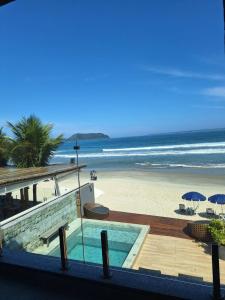 a resort with a swimming pool and a beach at Casatua Pousada in Juquei