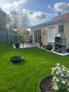 a backyard with a grill in the yard at La Maison des Plaisirs Love room in Champigny-sur-Yonne