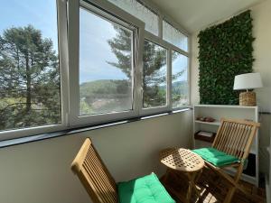 2 sillas y una mesa en una habitación con 2 ventanas en Apartament A&A, en Gura Humorului