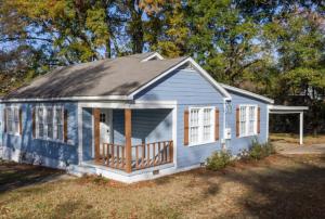 ein kleines blaues Haus mit einer Veranda auf einem Hof in der Unterkunft Backyard Beauty Bungalow in Jackson in Jackson