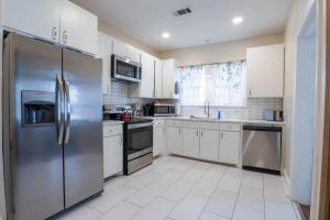 una cocina con electrodomésticos de acero inoxidable y armarios blancos en Backyard Beauty Bungalow in Jackson en Jackson
