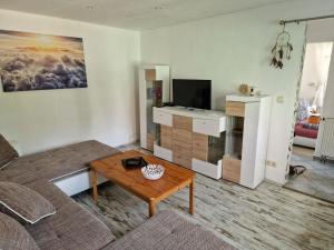 uma sala de estar com um sofá e uma mesa em Weißenspring 