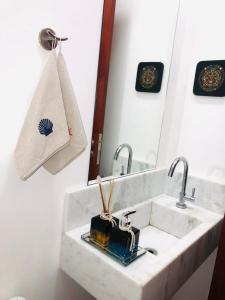 a bathroom with a sink and a mirror at Casa na Praia de Santiago, próxima a Maresias! in São Sebastião