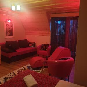 una sala de estar con muebles rojos y sillas rojas. en LOV APARTAMENT, en Kościelisko