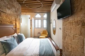 Villa Sera في عكا: غرفة نوم بسرير وتلفزيون على جدار