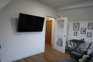 a living room with a flat screen tv on a wall at Two-Bedroom Apartment with Scenic Balcony View in Shipley
