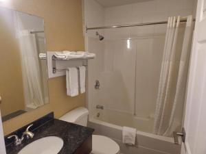 a bathroom with a shower and a toilet and a sink at Rodeway Inn & Suites in Kamloops