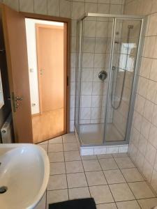 La salle de bains est pourvue d'une douche et d'un lavabo. dans l'établissement Ferienwohnung „Landidylle“, à Stemwede
