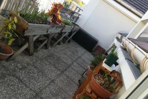 a balcony with potted plants and a table at Appartement loft. A 2km de la colline d'Elancourt in Trappes