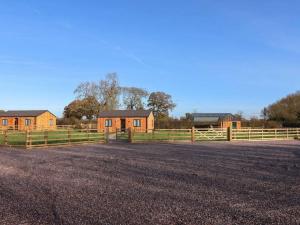 a fence next to a house and a field at Rowan Lodge in Ashbourne