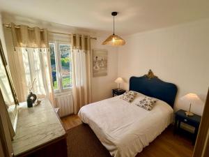 a bedroom with a bed with a blue headboard and a window at Maison de vacances in Olonne-sur-Mer