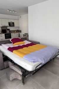 a large bed in a room with a kitchen at T2 Appartement Sunset Lodge à 250 m de la mer, 3 couchages in Narbonne-Plage