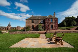 a house with a bench in front of it at Papple Farmhouse at Papple Steading in East Linton