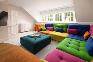 a living room with a colorful couch and ottoman at Papple Farmhouse at Papple Steading in East Linton