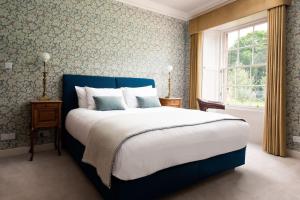 a bedroom with a large bed and a window at Papple Farmhouse at Papple Steading in East Linton