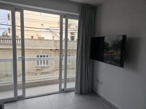 sala de estar con ventana grande y TV de pantalla plana en One bedroom apartment Msida, en Msida