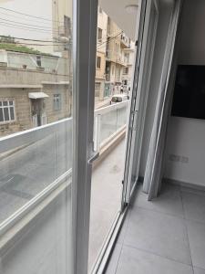 ventana abierta con vistas a un balcón en One bedroom apartment Msida, en Msida