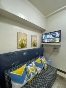 uma sala de estar com um sofá e uma televisão de ecrã plano em Cute and Cozy Solo 1 bedroom Condo unit in Baguio em Baguio