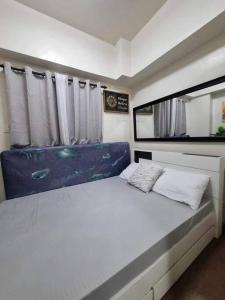 um quarto com uma cama grande e uma janela em Cute and Cozy Solo 1 bedroom Condo unit in Baguio em Baguio
