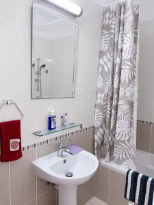 a bathroom with a sink and a shower curtain at Elysia Park in Paphos City
