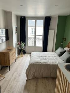 a bedroom with a large bed and a large window at Terasse avec superbe vue sur le marché de Dieppe in Dieppe