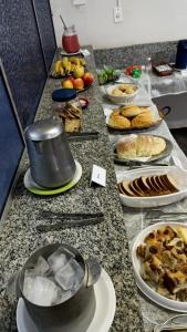 una mesa con muchos platos de comida. en HOTEL TABARANA en Ubarana