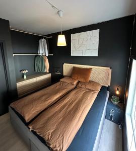 a bedroom with a large bed with brown sheets at A Place To Stay Stavanger, apartment 4 in Stavanger