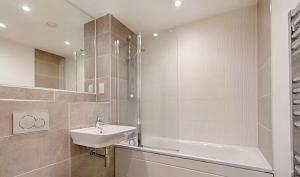 a bathroom with a sink and a bath tub at City Centre Rooms in Cardiff