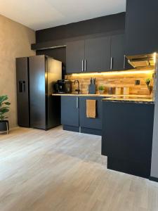 a kitchen with black cabinets and a black refrigerator at A Place To Stay Stavanger, apartment 4 in Stavanger