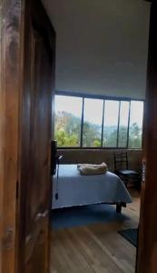 a bedroom with a bed and a large window at Hospedaje Leonor in Cuenca