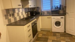 Foleshill的住宿－C.K. APARTMENT，厨房配有洗衣机和洗衣机。