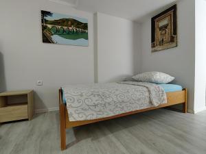 um quarto com uma cama e uma fotografia na parede em Dodir prirode em Višegrad