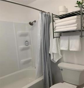 a bathroom with a shower and a toilet and towels at The best lake view in Ozark. in Lake Ozark
