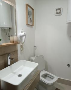 a bathroom with a white sink and a toilet at Sunčani apartman 2 in Krupanj