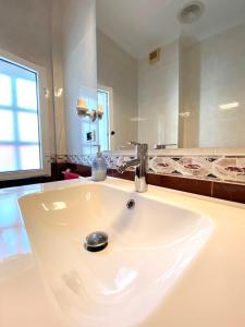 y baño con lavabo blanco y espejo. en Apartamento Rivela, en Burela de Cabo