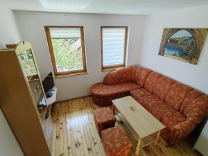 uma sala de estar com um sofá e uma mesa em Dodir prirode em Višegrad
