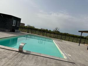 une grande piscine bleue sur une terrasse dans l'établissement Villa eden, à Agnone Bagni